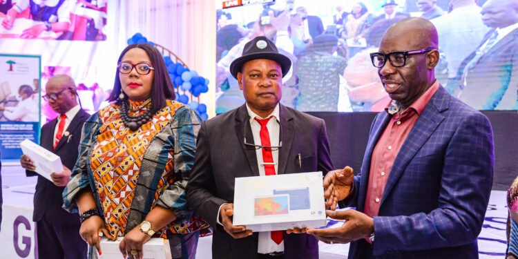 Edo State Commissioner for Education, Dr. Joan Osa Oviawe; Principal, Ebhoiyi Senior Secondary School, Uromi, Elder Ojiezele Dennis, and Edo State Governor, Mr. Godwin Obaseki, during the governor’s presentation of electronic devices to school principals in Edo State, at the New Era College, in Benin City.