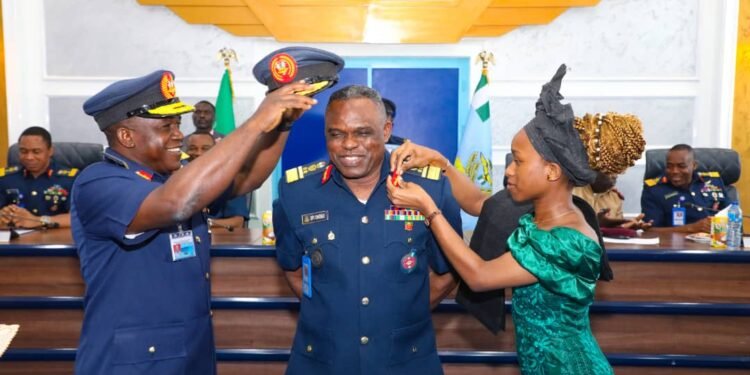 •The Chief of Air Staff, Air Marshal Isiaka Amao (l), being assisted by a young lady as he decorates one of the terminally promoted AVMs in Abuja, Dec 16, 2022.