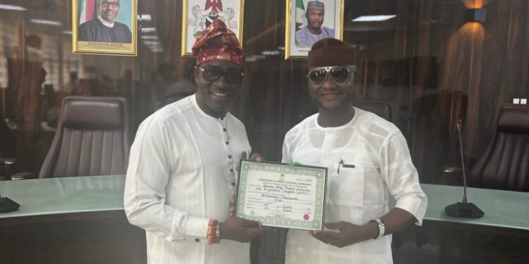 *House of Reps member-elect Billy Osawaru (l) receives his CoR