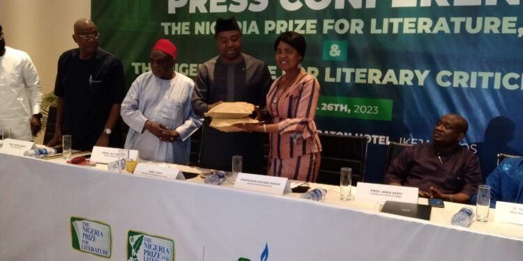 *NLNG's GM, External Relations and Sustainable  Devt, Mr Andy Odeh (l), handing over the entries to the Chair of the Prize’s Advisory Board, Professor Akachi Adimora-Ezeigbo
