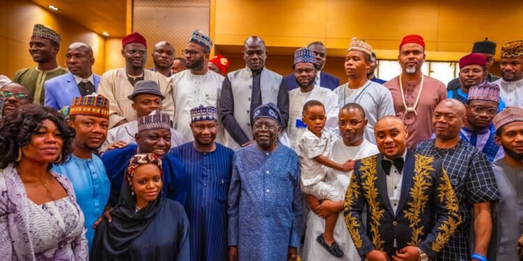 **President Bola Tinubu (m) flanked by Nigerians in Indian