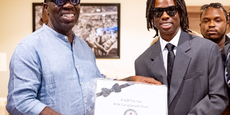 Edo State Governor, Mr. Godwin Obaseki (left) presenting a souvenir to Edo-born musical prodigy, Divine Ikubor, popularly known as Rema, after a lunch, at the Government House, in Benin City, on Friday, March 29, 2024.