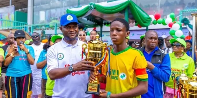 Edo State Deputy Governor HE Rt Hon Dennis Idahosa (l), presenting a trophy to the captain of Benin Technical College, winners of the event's football match